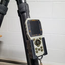 Thermal rifle scope with digital display and control buttons mounted on tripod for predator hunting