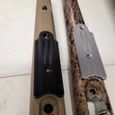 Black and gray rifle scope mounts on tan and camo gun stocks for thermal optics setup